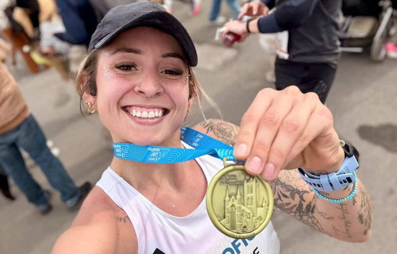 Justine Run Wild, souriante avec ses paillettes et sa médaille après une course
