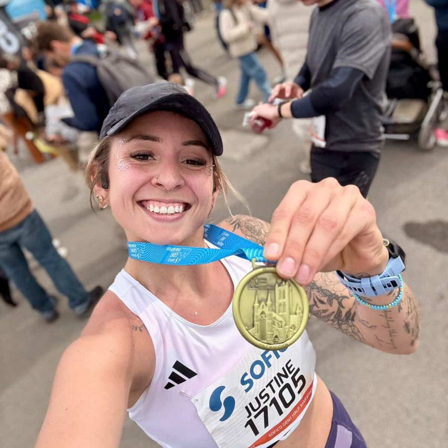 Justine Run Wild, souriante avec ses paillettes et sa médaille après une course