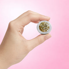 Paillettes Parachute Doré — pot tenu entre deux doigts pour visualiser son format