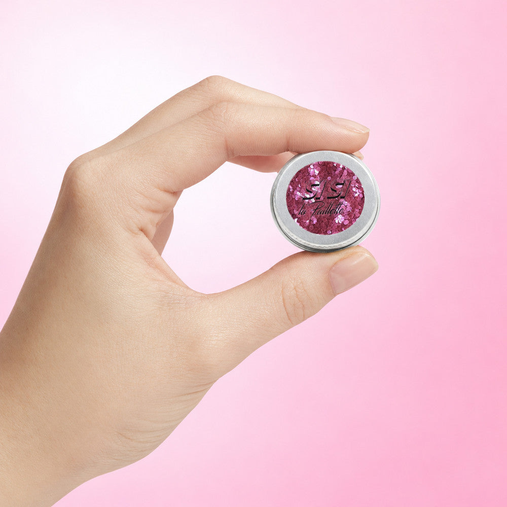Paillettes Pure Fuchsia Moyennes — pot tenu entre deux doigts pour visualiser son format